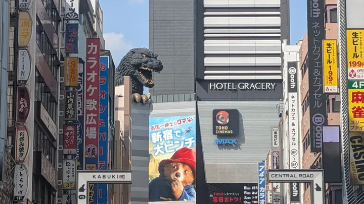Godzilla head overlooks a paddington poster in Tokyo