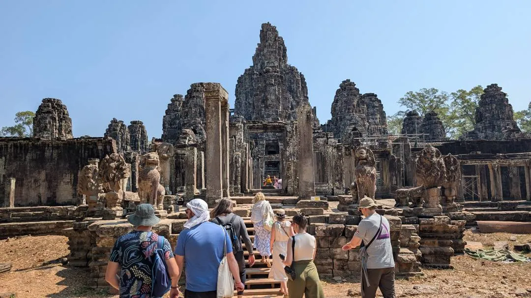A group of people entering the ruins of the Bayon temple