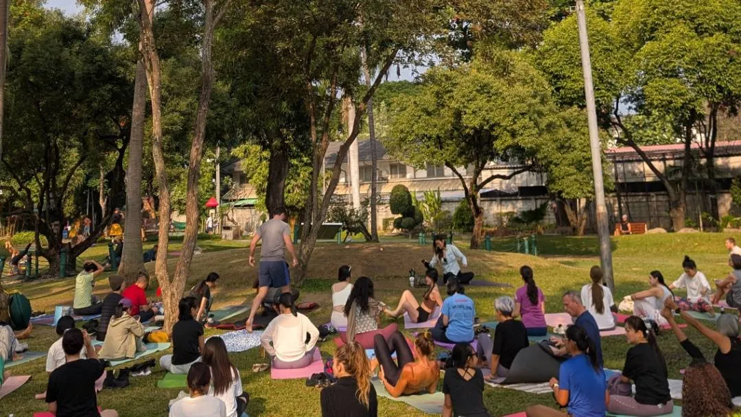 A group getting ready to do yoga in a park