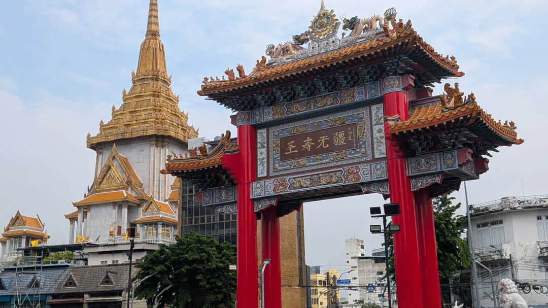 A Chinese arch on a roundabout with a temple in the background