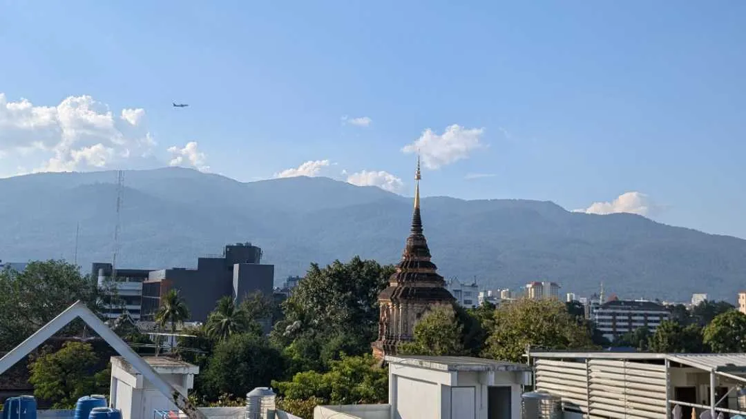 Pic taken from a rooftop showing various building and mountains in the background