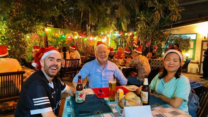 3 people sitting at a table for Christmas dinner in a beer garden
