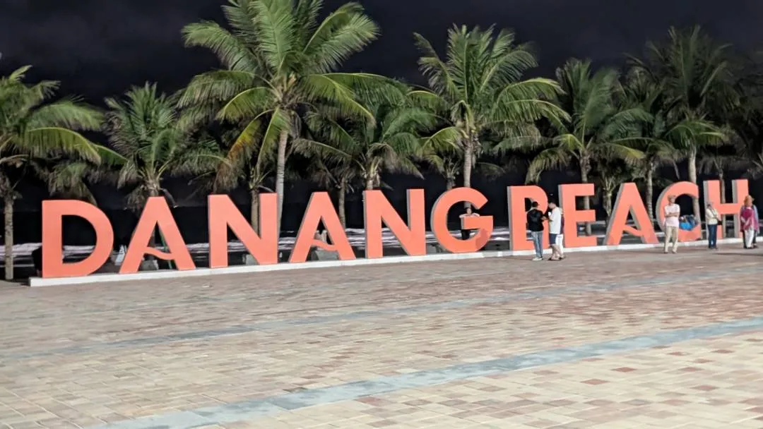 A large sign saying Da Nang Beach at night time