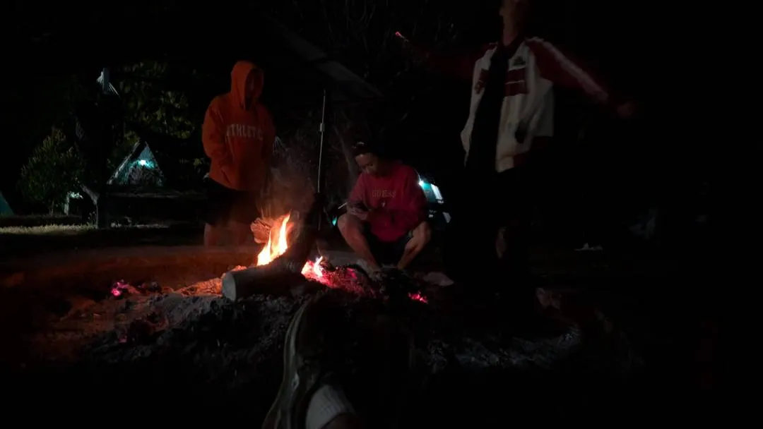 A campfire at night with people around it