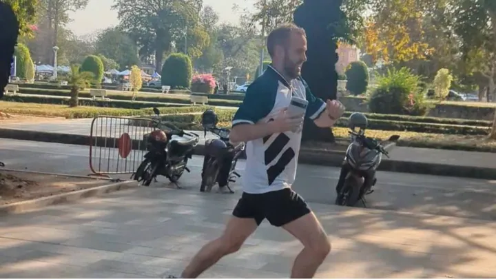 Side profile of a handsome athlete in a Liverpool jersey running