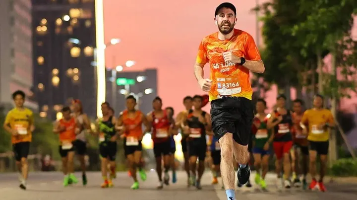 A man night running in the foreground with a group of runners behind him in the background