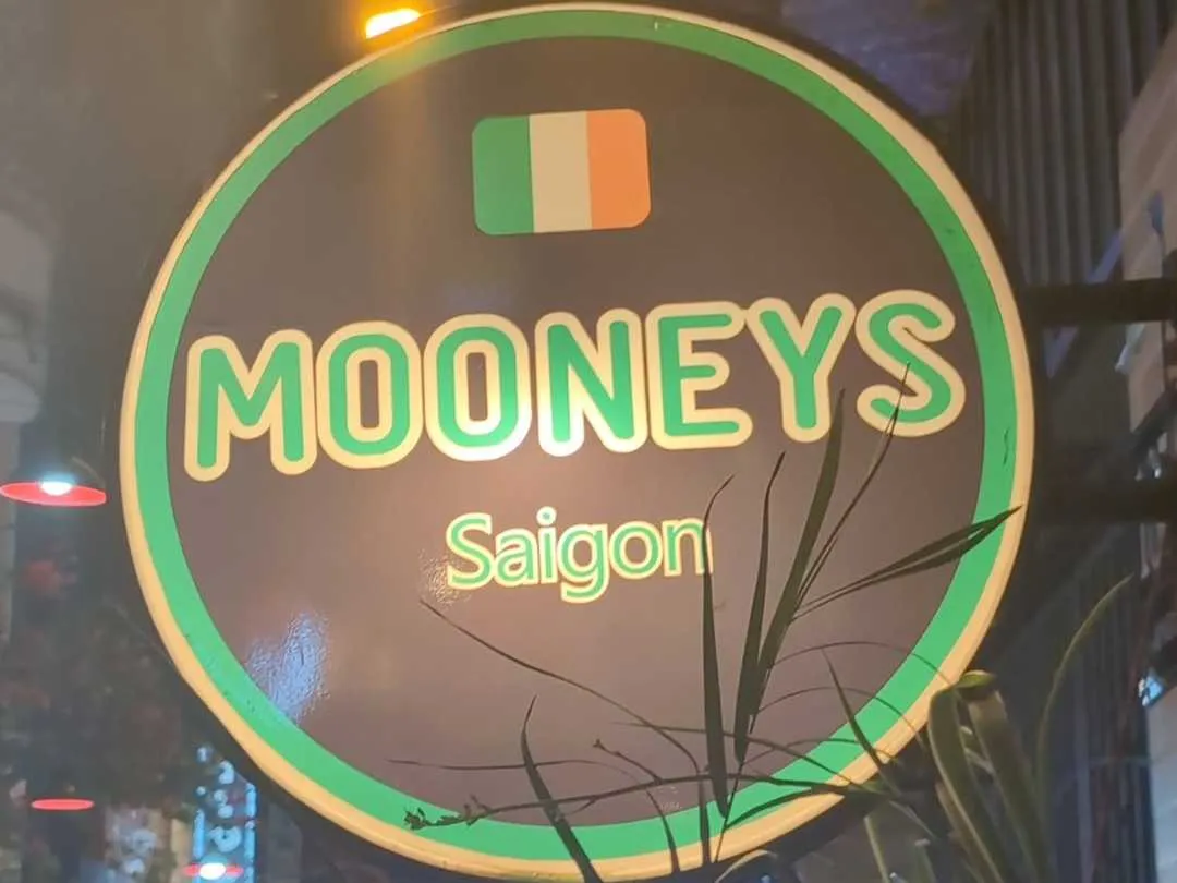 A circular lit up sign for Mooney's pub