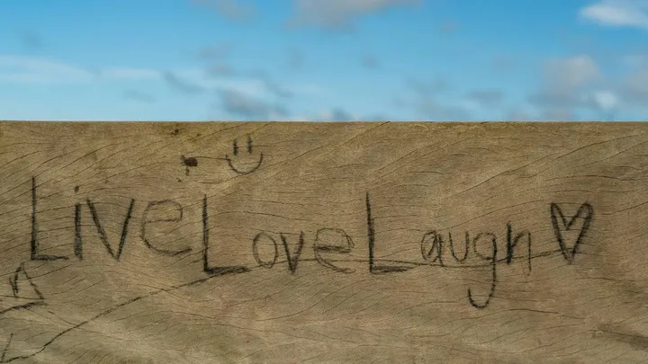 Graffiti on a plank of wood saying the trite Live, Love, Laugh