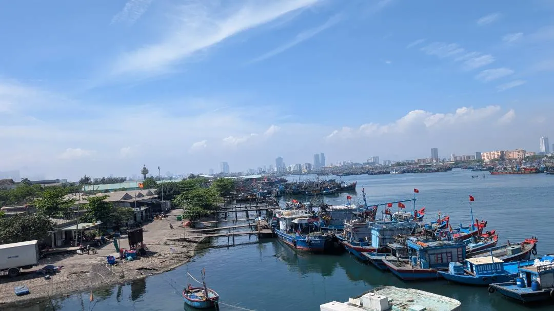 Da Nang downtown picture taken from a bridge. A body of water with boats on it in the centre