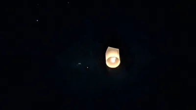 A lantern floating up to the sky at night