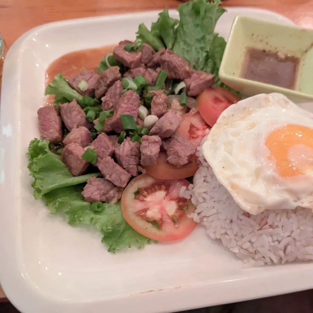 A picture of Lok Lak, a Cambodian dish of beef, rice and egg