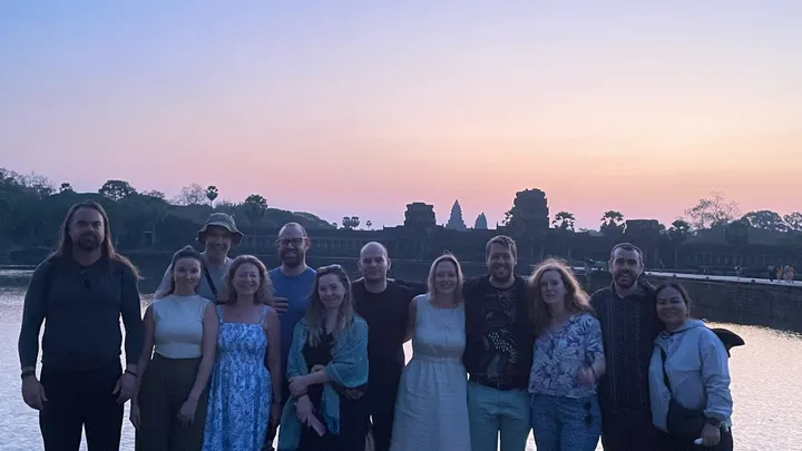 A group of people pose for a photograph at an Angkor Wat sunrise