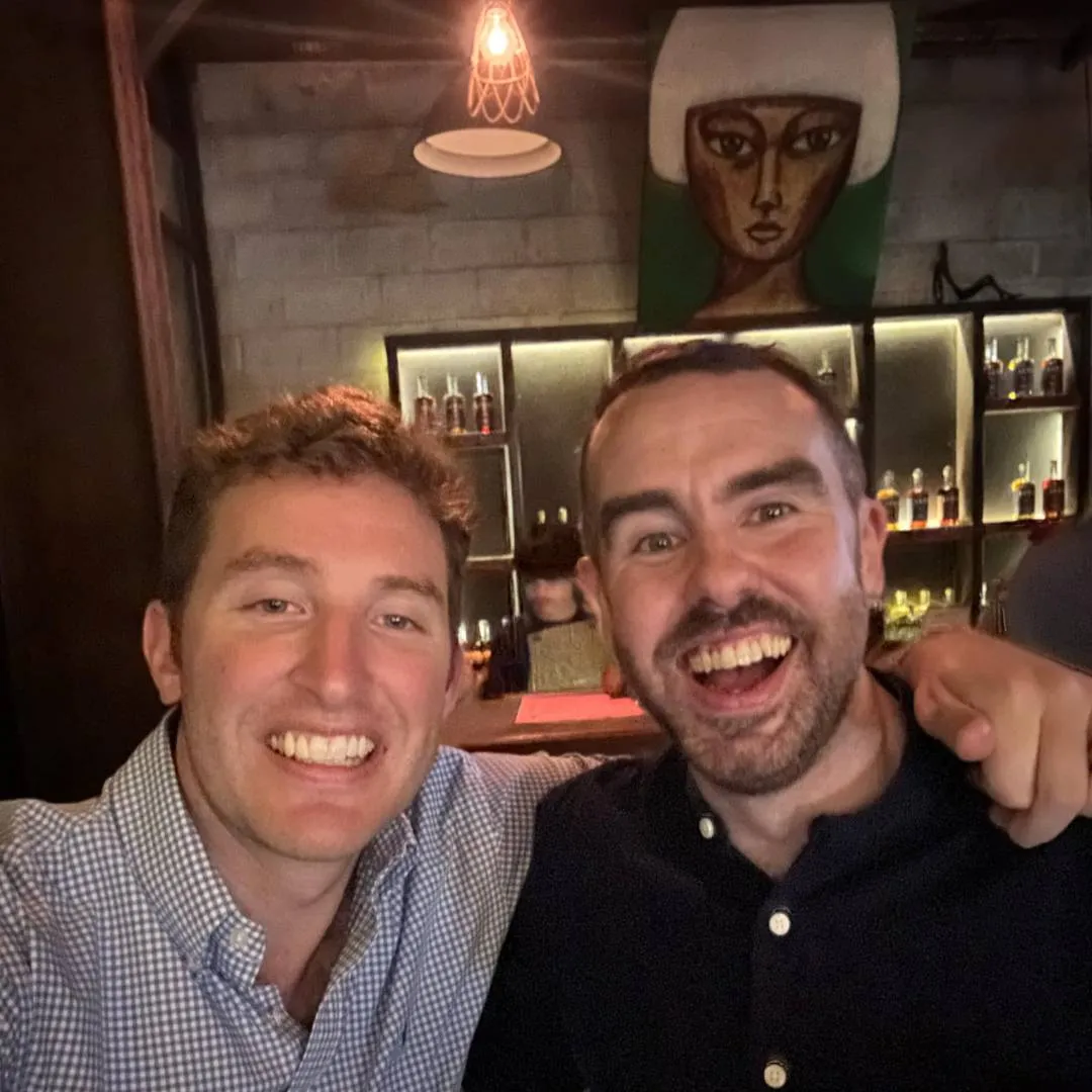 Two handsome men taking a selfie in a gin bar
