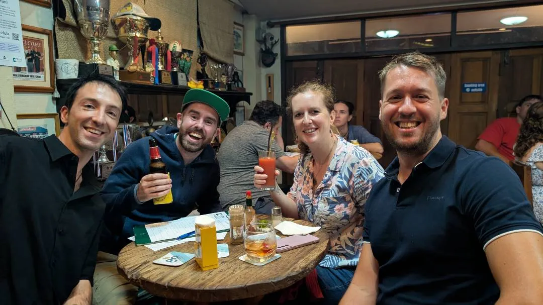 A group of people in a bar celebrating after winning a quiz