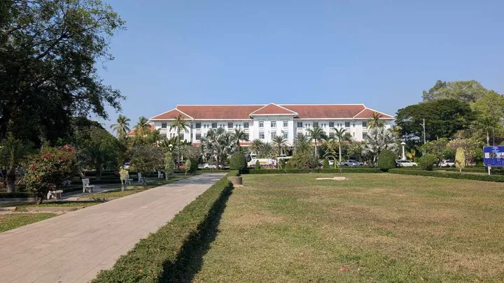 Picture of the Raffles Grand Hotel d'Angkor – a large white building with well kept gardens