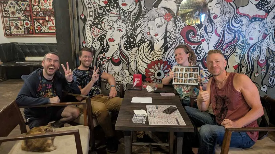 Four people smiling after taking part in a table quiz
