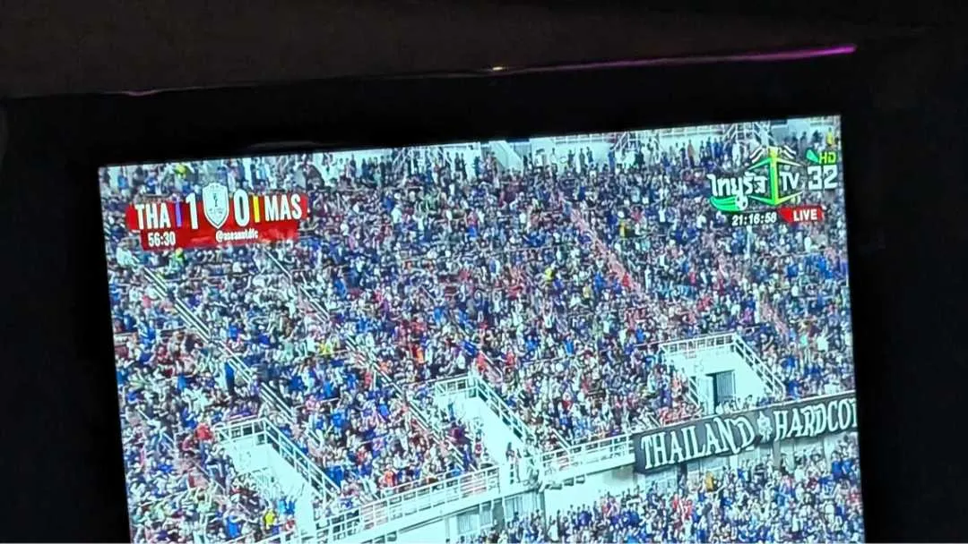 A TV screen showing a football match