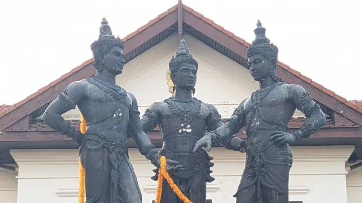 Statues of three Buddhist kings in conversation with one another