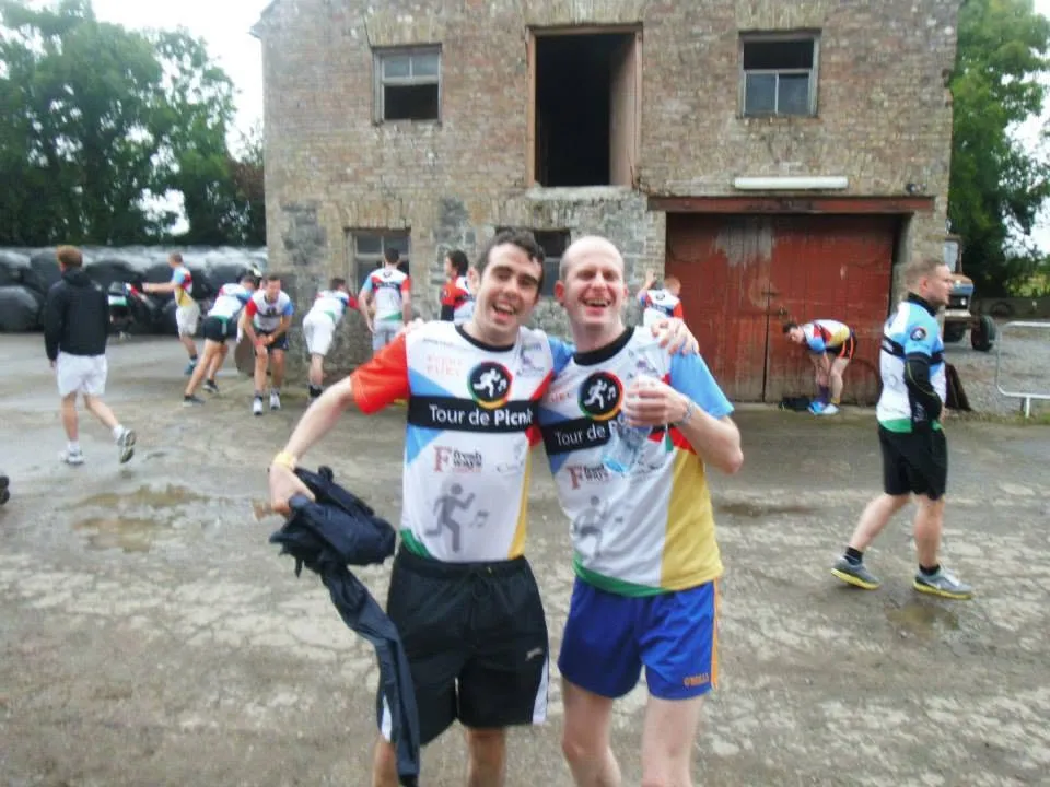 Two men pose at the start of a run